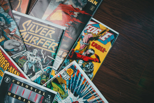 A stack of comic books sitting on a table, representing a collection ready for organization and storage.
